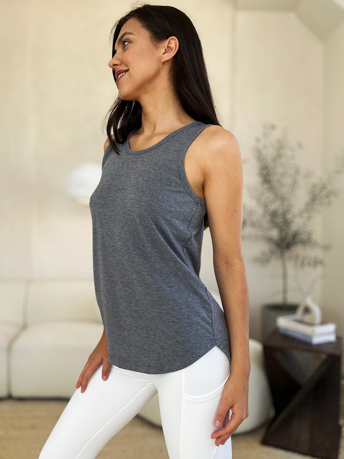 ShopBasicbae Basic Bae full-size round neck tank top with curved hem, displayed on a hanger, in a casual and comfortable style.